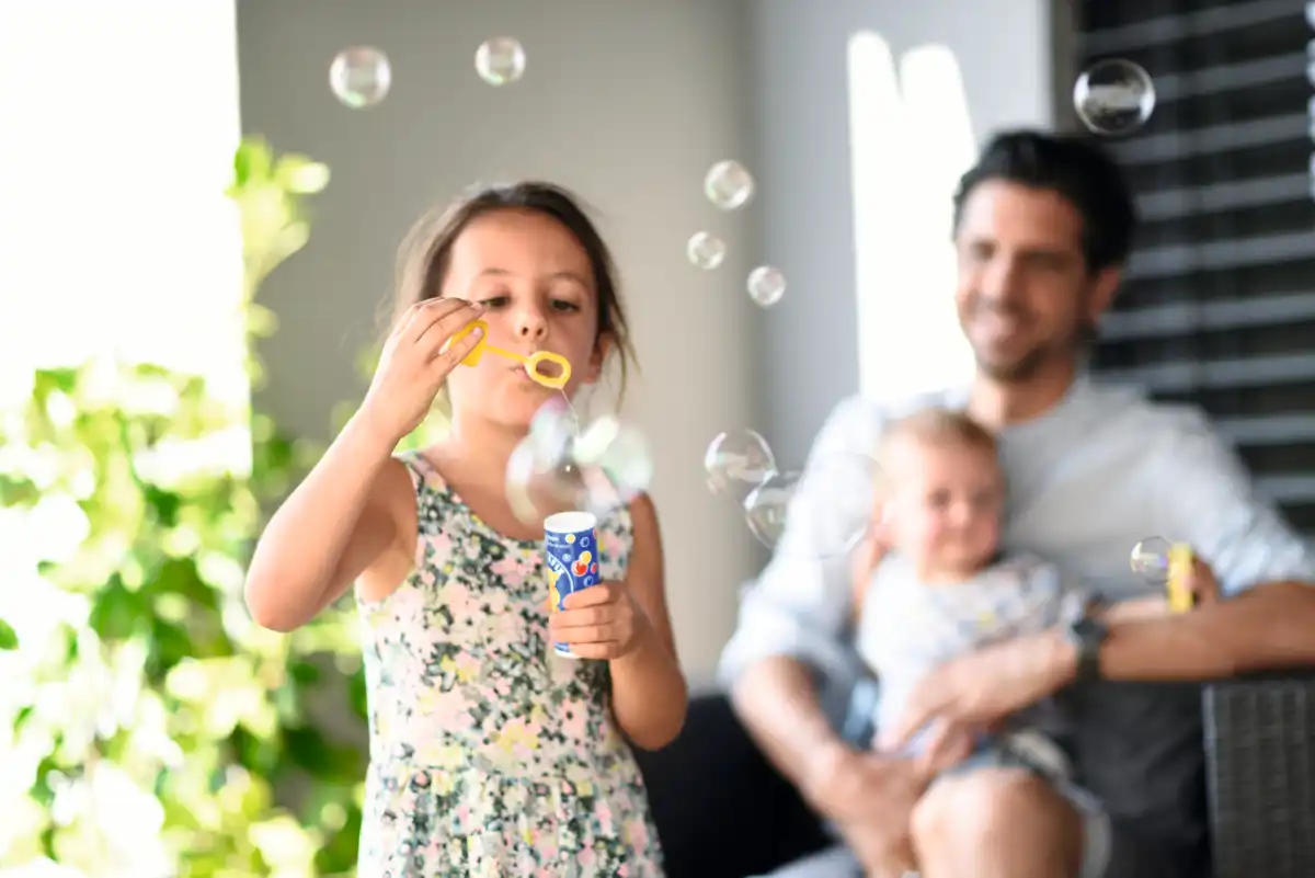 Rollladen für die Fenster Kind spielt mit Seifenblasen im Garten