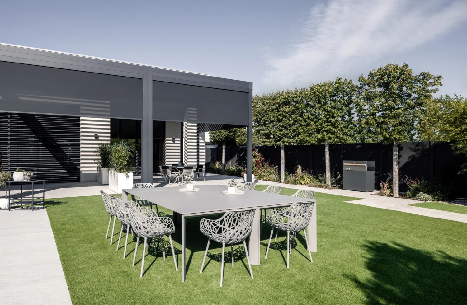 Moderner Außenbereich mit stilvoller Gartenmöbelgruppe auf grünem Rasen