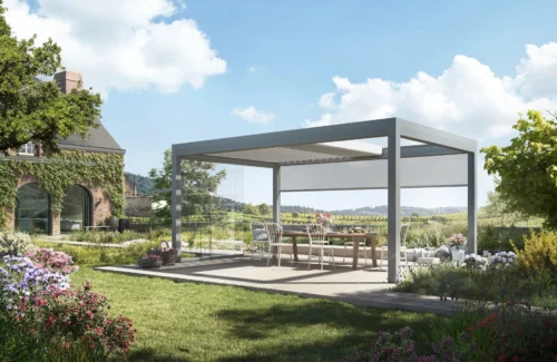 Moderne Pergola auf einer grünen Terrasse mit Blumengarten und Landhaus im Hintergrund